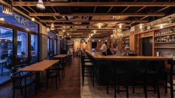 Cozy interior of the St. Martins Pub with stylish bar and wooden beamed ceiling with evening lighting