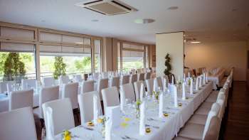 Festively decorated room with elegant table arrangement, white covers and fine details