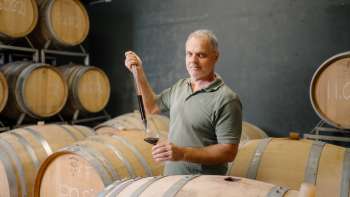Harry Zech takes wine from the barrique barrel for tasting with a pipette - traditional winemaking in Schaan.