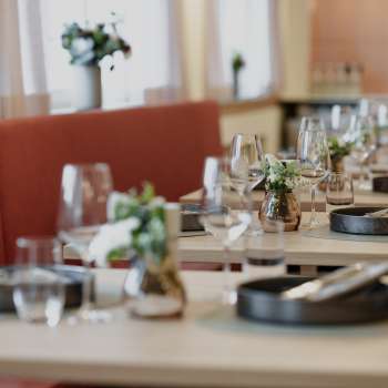 Close-up of stylishly laid tables in the RUUF restaurant with dark crockery and flower vases