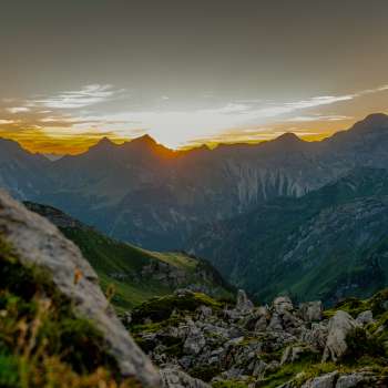 Sunset on the ridge - The sun sinks behind the mountain peaks and bathes the alpine panorama in warm evening colors
