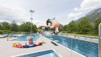 unge somersaults from the 1-meter board into the pool at Mühleholz swimming pool - pure summer fun.