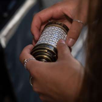 Close-up of hands with a mysterious combination lock in the Malbun Escape Room