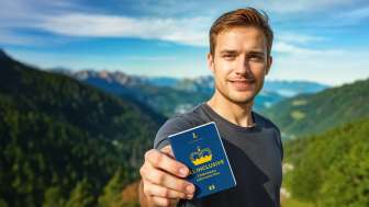 Man shows the ALL INCLUSIVE Adventure Pass with mountain panorama in the background