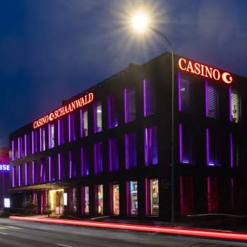 The Casino Schaanwald in the dark, impressively illuminated with purple light accents - a popular destination for night owls in Liechtenstein.