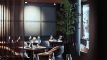 Modern restaurant with stylish interior design, comfortable armchairs and large windows