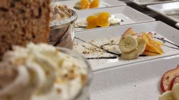 Richly laid table with small dessert glasses, fruit and garnish for a sweet buffet