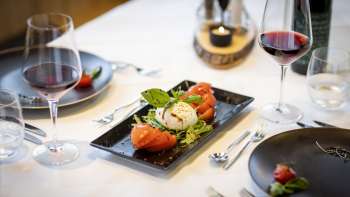 Another view of the laid table, focusing on the modern black plates and the dishes in the center.