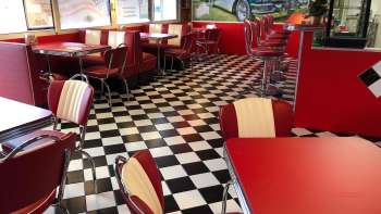 Interior of the 1950 American Diner red tables and black-and-white flooring