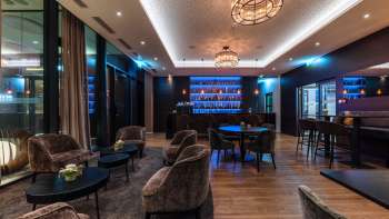 Cozy bar with stylish lighting and a selection of spirits.