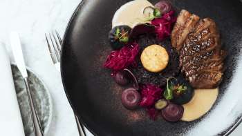 Stylishly prepared food on a black plate in Chapter Two