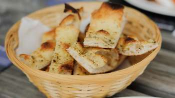 A basket of fresh, crusty bread on a set table