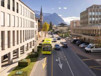 A LIEmobile bus drives through Vaduz against the backdrop of the Alps and modern architecture
