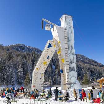 The icy climbing tower in Malbun surrounded by winter guests against an alpine backdrop - a highlight for winter sports enthusiasts in Liechtenstein.