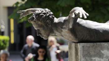Bronze sculpture Phoenix by Doris Bühler in Vaduz, a human body in a flying position mounted on a plinth.