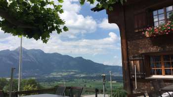 Traditional building with sunny terrace and mountain panorama in the background