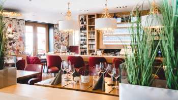 nterior of the PUR Restaurant & Bar with elegant red upholstered chairs and stylishly laid tables.
