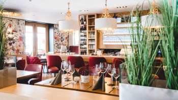 nterior of the PUR Restaurant & Bar with elegant red upholstered chairs and stylishly laid tables.
