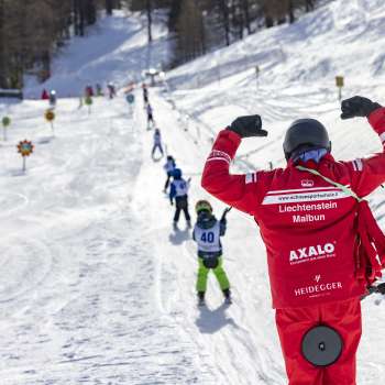 Ski course at Malbi Park in Malbun with colorful helmets and dedicated instructors - safe learning in a child-friendly environment