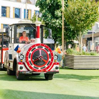 The Städtlezügle travels through the pedestrian zone of Vaduz in the sunshine.