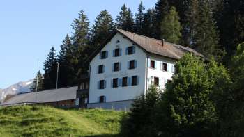 Traditional mountain inn Sücka in the middle of a green landscape and surrounded by forests