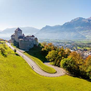 Vaduz Castle on a hill overlooking the Rhine Valley and surrounding mountains.