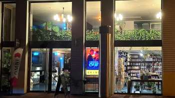 Illuminated exterior view of the Skino cinema in Schaan at night, with large glass fronts and an inviting atmosphere.