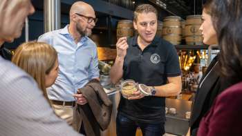 An employee explains brewing ingredients to a group of interested guests during a tour of the brewery.