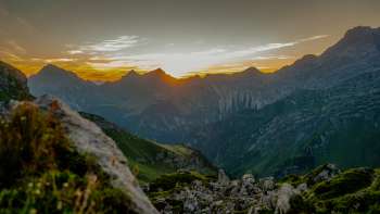 Sunset on the ridge - The sun sinks behind the mountain peaks and bathes the alpine panorama in warm evening colors