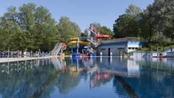 View of the large swimming pool with colorful slide landscape at the Mühleholz swimming pool in Liechtenstein.