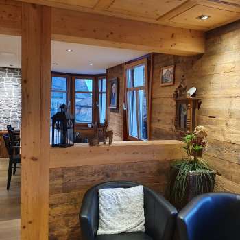 Inviting interior with wooden walls, stylish seating area and natural lighting