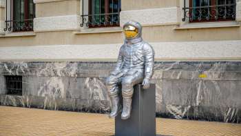 Side view of a silver astronaut sculpture with a gold-colored visor at the Bad Ragartz exhibition in Vaduz