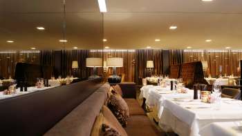 Elegant restaurant with mirrored tables and subdued lighting