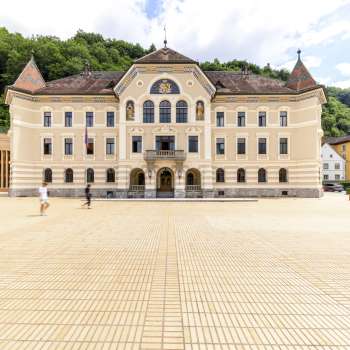 Vaduz government building with bright façade and square in front.