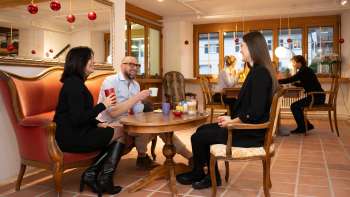 Three people in the Keramikcafé in Liechtenstein with coffee and tea in a cozy lounge atmosphere.