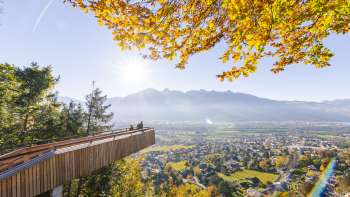 Viewing platform on the forest adventure trail in Vaduz with a view of the sunny valley Viewing platform on the forest adventure trail in Vaduz with a view of the sunny valley