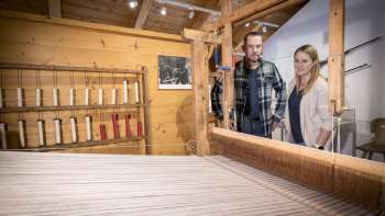 Visitors look at the loom in the Walser Museum