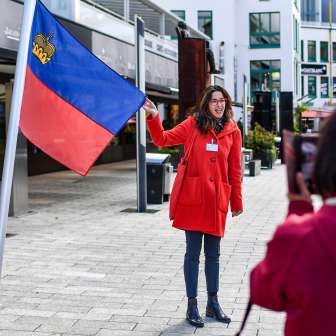 City guide presents the Liechtenstein flag during a guided tour through the center of Vaduz