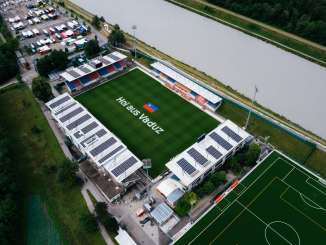 Aerial view of the Rheinpark Stadium in Vaduz with "Hoi aus Vaduz" lettering on the pitch and the Rhine in the background