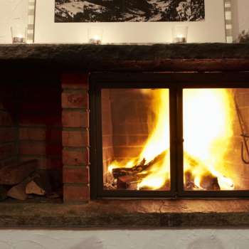 Warm fireplace with burning wood and atmospheric light.