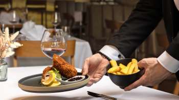 Served dish with breaded meat and French fries in a modern presentation in the Alpspitz restaurant.