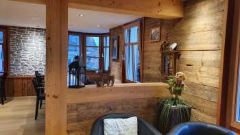 Inviting interior with wooden walls, stylish seating area and natural lighting