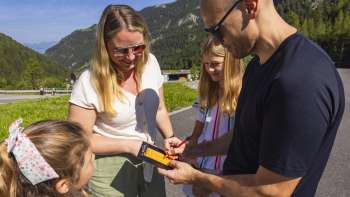 Family enters minigolf points in a scorecard