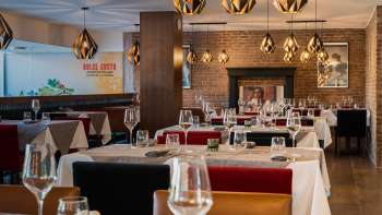 Elegant restaurant with stylish furnishings, white tablecloths and a fireplace for a cozy atmosphere.