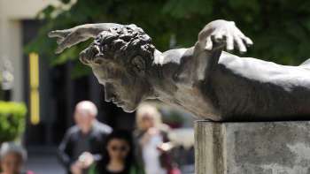 Bronze sculpture Phoenix by Doris Bühler in Vaduz, a human body in a flying position mounted on a plinth.