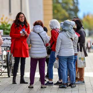 Tour group with city guide in red coat on a guided tour through the center of Vaduz in Liechtenstein