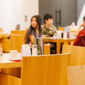 Guests sit in the bright café area of the Art Museum and chat