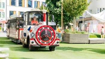 The Städtlezügle travels through the pedestrian zone of Vaduz in the sunshine.