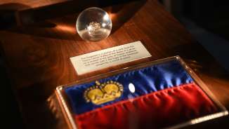 Exhibit in the Liechtenstein TreasureChamber: Liechtenstein flag with golden crown and glass globe with historical find