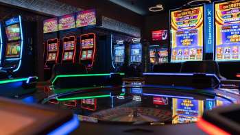 View of the modern slot machine area at Casino Admiral Triesen with colorfully illuminated slot machines.